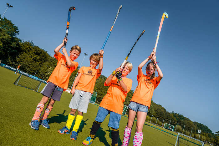 Jongeren poseren voor de groepsfoto tijdens het hockeykamp in Noord-Brabant in de zomer.