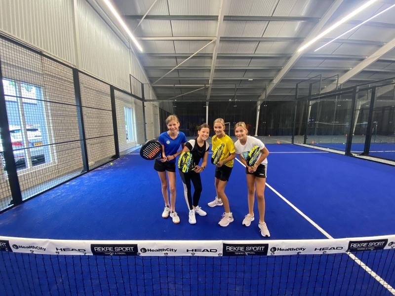 groepje meisjes in de padelzaal voor een groepsfoto op padelkamp noord-brabant zomer