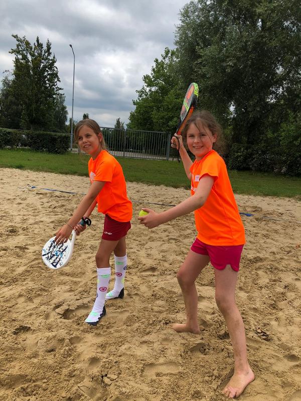 twee meisjes buiten op het zand op padelkamp noord-brabant zomer