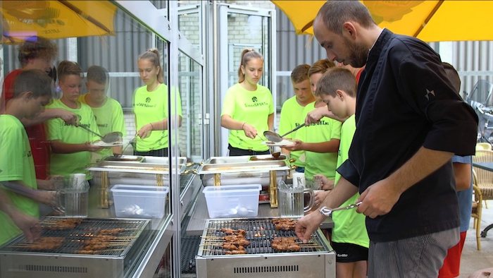 Het buffet Jongens aan het muurklimmen op voetbalkamp in Brabant tijdens de zomer.
