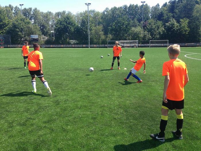 Jongeren tijdens de voetbaltraining Jongens aan het muurklimmen op voetbalkamp in Brabant tijdens de zomer.