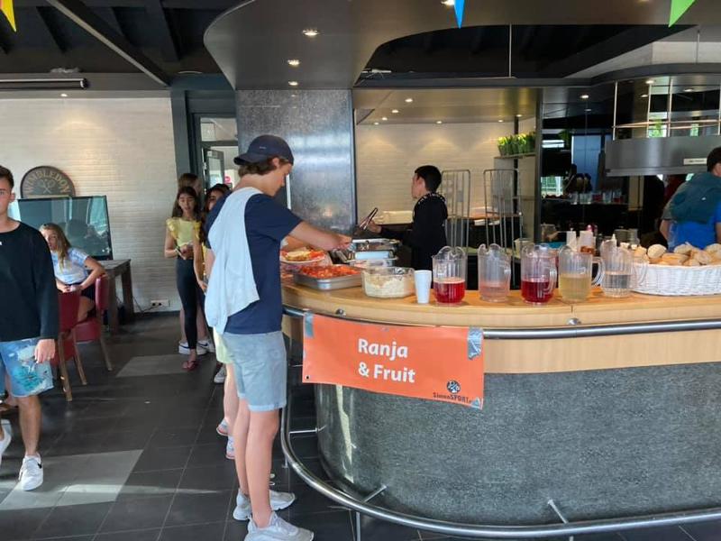 jongen haalt drinken en eten tijdens het buffet op zomerkamp noord-brabant 