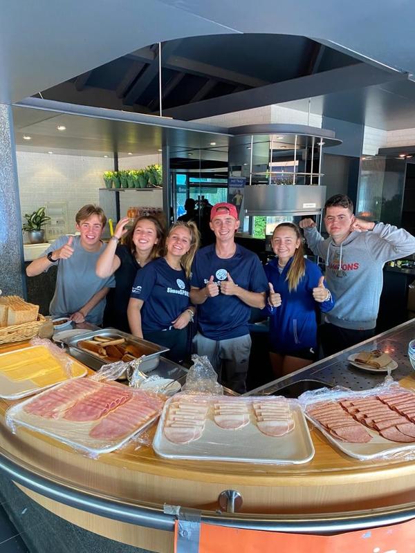groep begeleiders poseren bij het eten op zomerkamp noord-brabant 