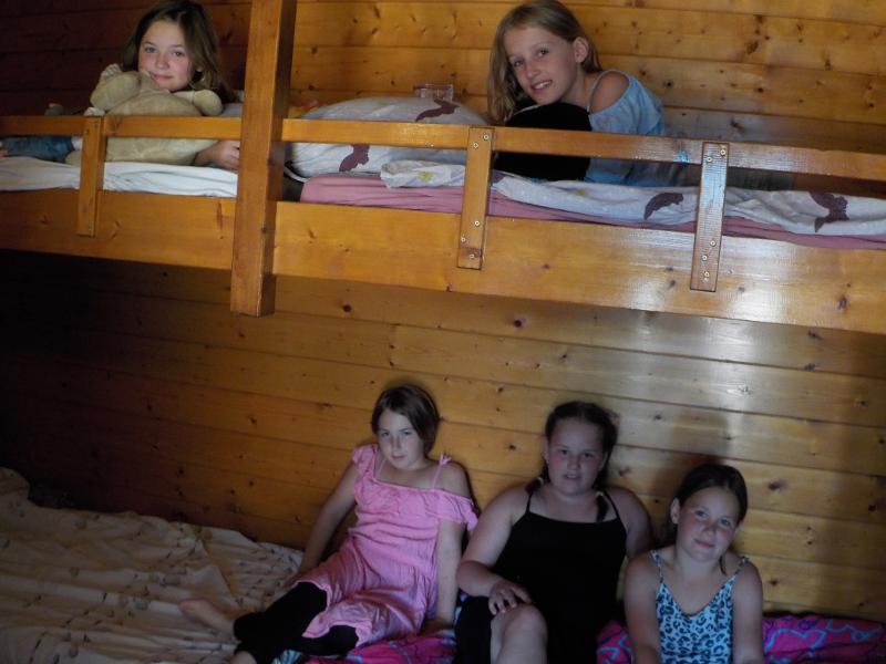 meisjes liggen op bed in houten accommodatie op zomerkamp nederland girl camp