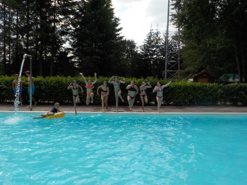 meisjes springen in zwembad vanaf de rand op meiden zomerkamp nederland girl camp