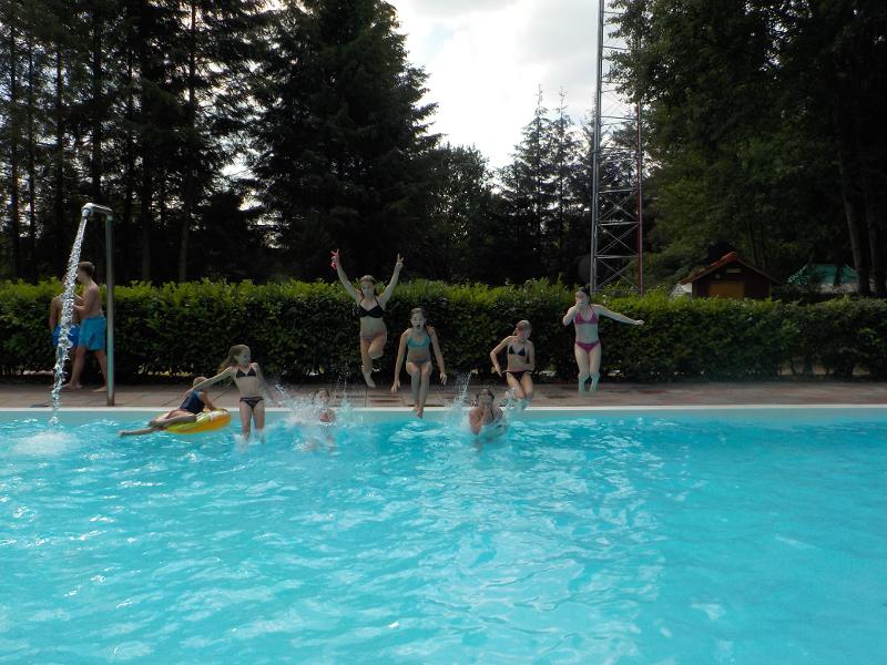 meisjes springen vanaf de rand in het zwembad op meiden zomerkamp nederland girl camp