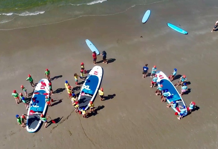 Jongeren met supersup op het strand tijdens zomerkamp Amsterdam in de zomer.