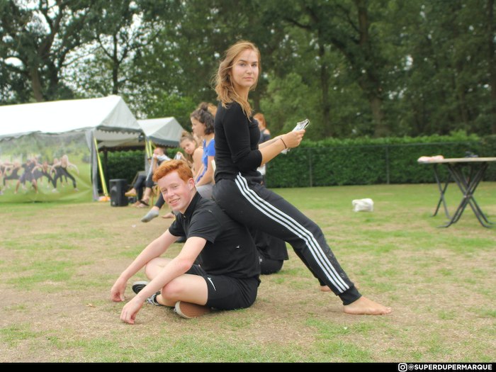 Meisje zit op een jongen tijdens het danskamp in Noord-Brabant in de zomer.