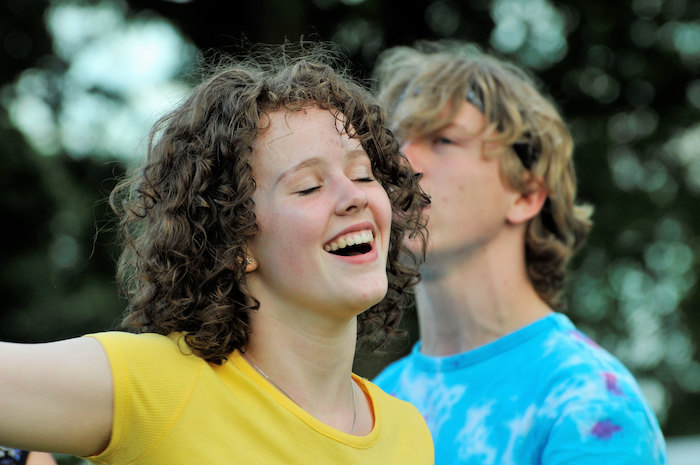 Een meisje met gesloten ogen tijdens het musicalkamp in Noord-Brabant in de zomer.