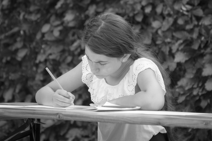 Meisje schrijft brief tijdens musicalkamp