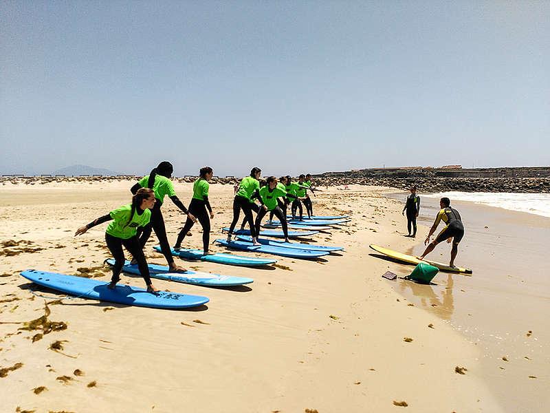 Deelnemers tijdens taalreis Spaans leren te surfen op een strand