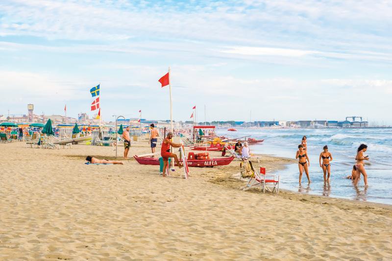 Een groep toeristen aan het strand van de kust van Italië tijdens een jongerenreis