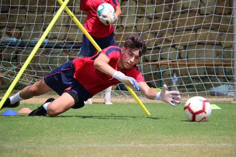 Een keeper red een bal tijdens een voetbalkamp Spanje