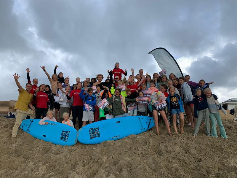 Groepsfoto op het strand tijdens een surfkamp