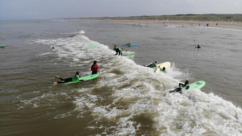 Jongeren zijn aan het suppen tijdens een surfkamp