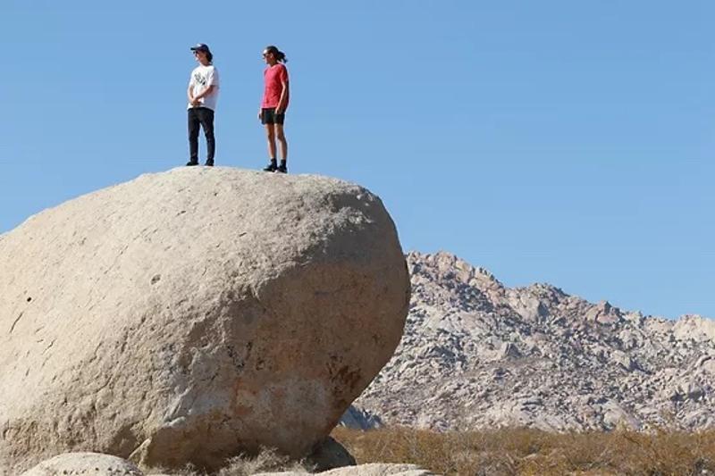 Een foto van deelnemers aan een groepsreis Amerika boven op een grote rots