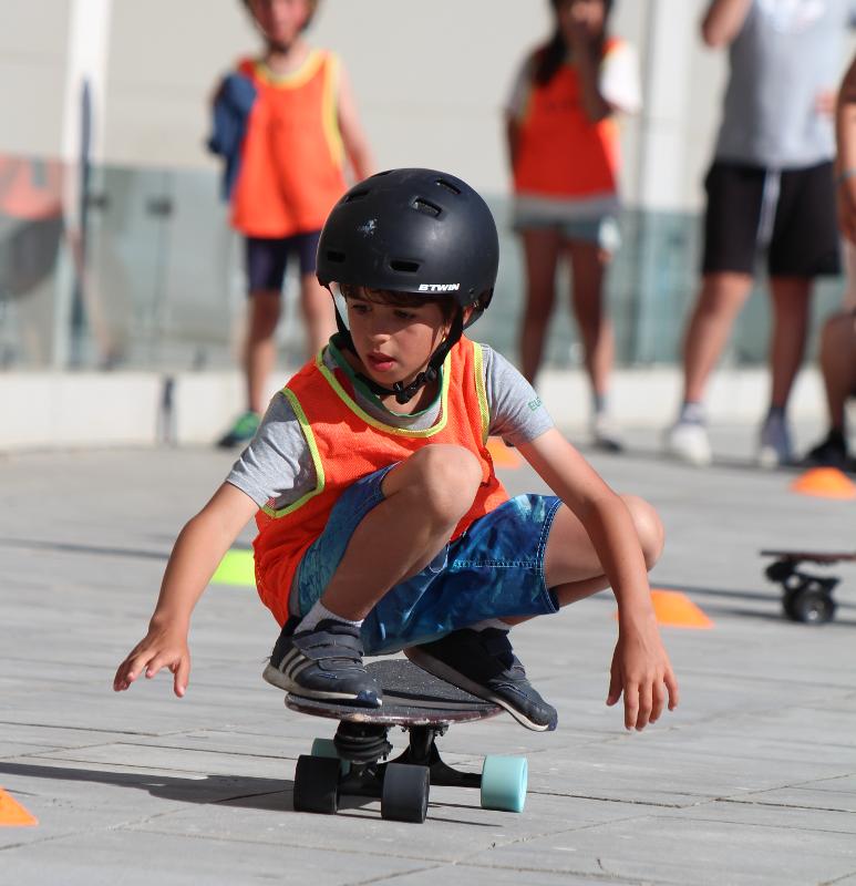 Een jongen tijdens een surfkamp in Portugal is aan het skateboarden op de straat
