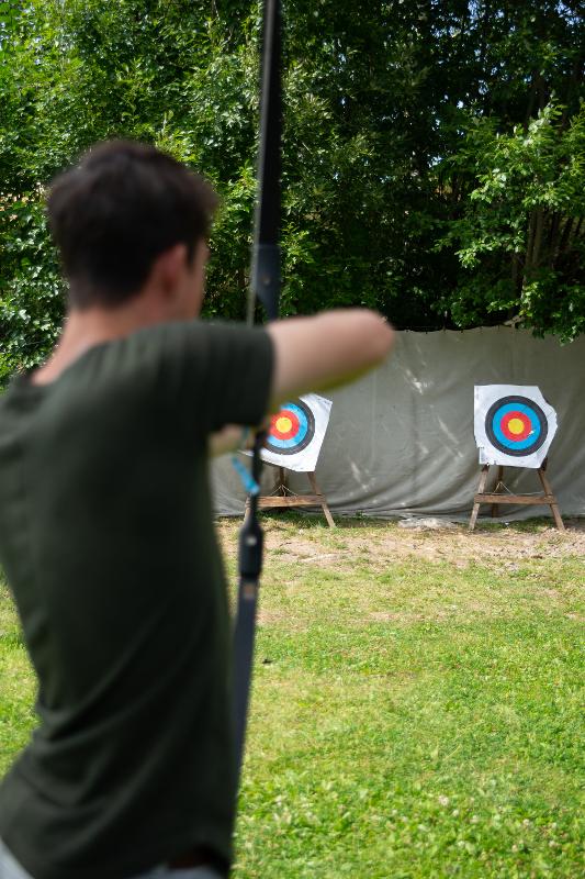 Jongen is aan het boogschieten tijdens een avonturenkamp