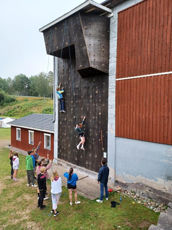 Groepje deelnemers gaat klimmen op een klimmuur tijdens een avonturenkamp