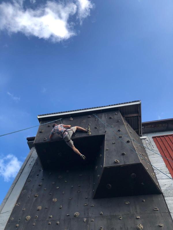Een jongen beklimt een klimmuur tijdens een avonturenkamp