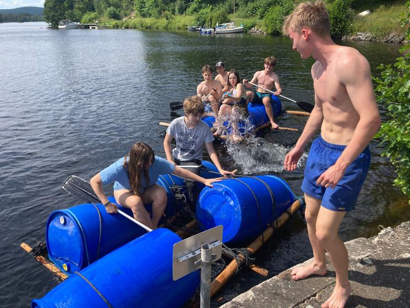 Jongeren bouwen een vlot op een meer tijdens een avonturenkamp