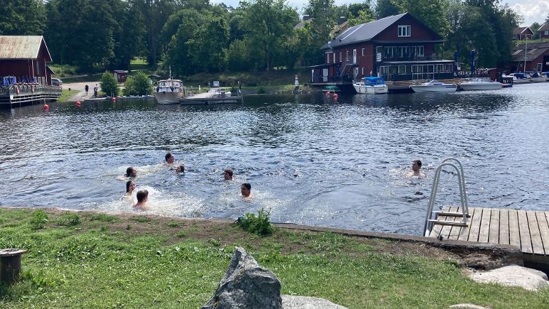Jongeren zwemmen in een meer tijdens een avonturenkamp
