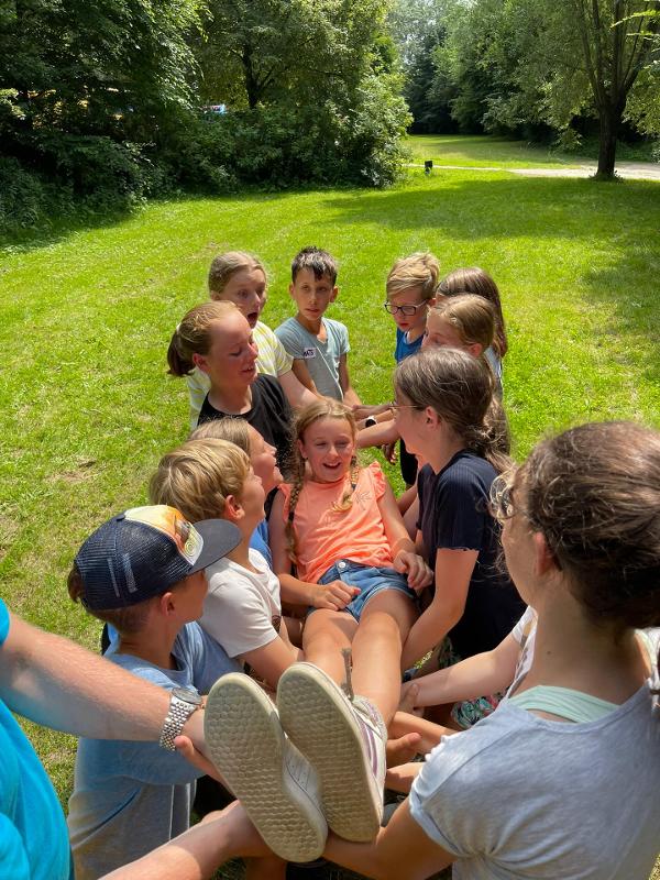 kinderen dragen meisje op avonturenkamp ronse