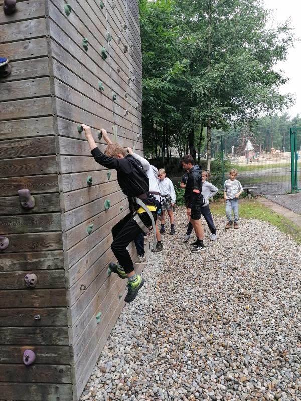 jongens klimmen buiten tegen muur op avonturenkamp ronse