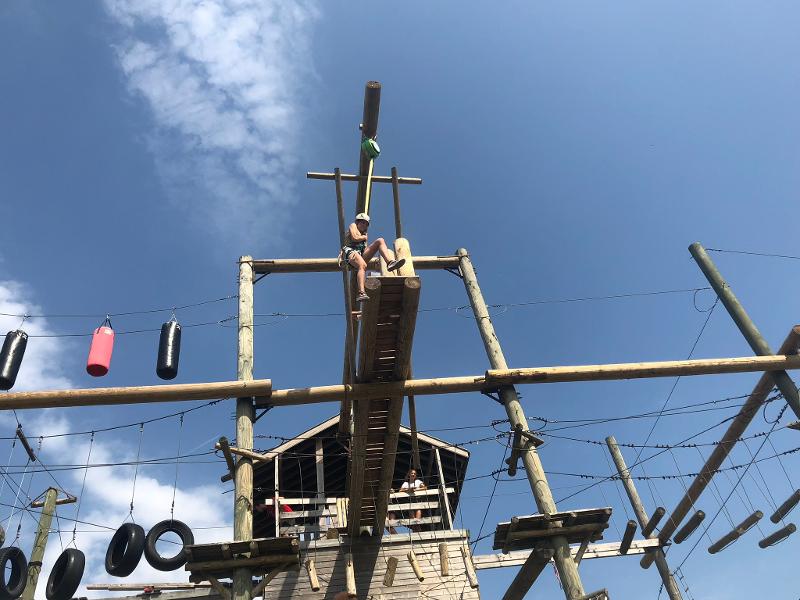 foto van meisje die hangt een klimtoren op avonturenkamp ronse