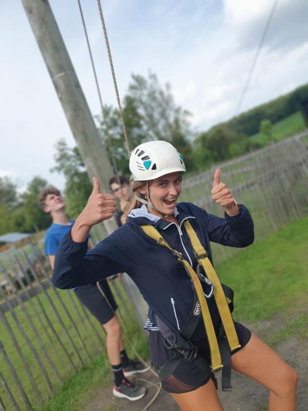 meisje met helm steekt duimen omhoog op avonturenkamp ronse