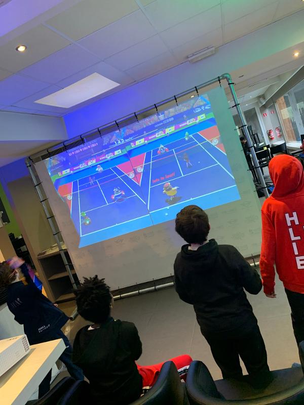 jongens spelen mario spel op beamer op gamekamp schoten
