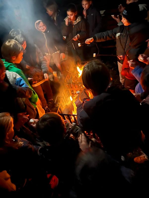 kinderen roosteren marshmallows bij kampvuur op outdoorkamp ronse