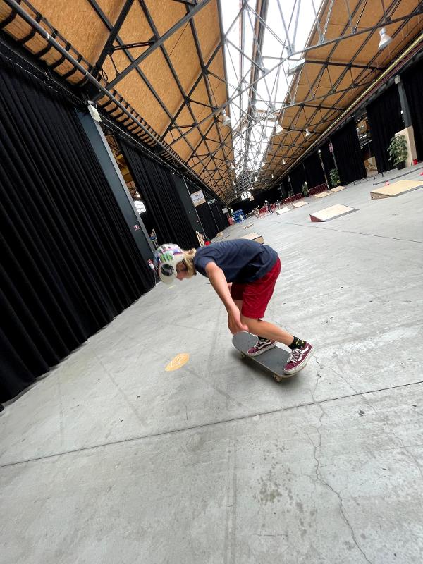 jongen rijdt op skateboard in hal op skatecamp schoten