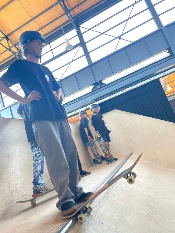 jongen staat bovenaan halfpipe op skatekamp belgische kust
