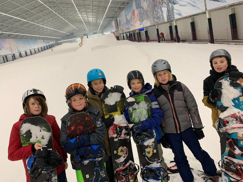 kinderen met snowboard in skihal op sportkamp schoten