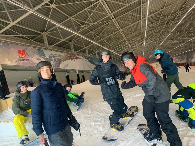 jongens op snowboard poseren voor foto op sportkamp schoten