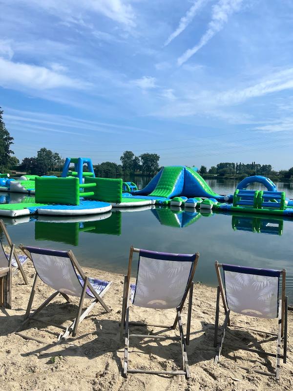 strandstoelen op het zand met water en waterparcours op watersportkamp waregem