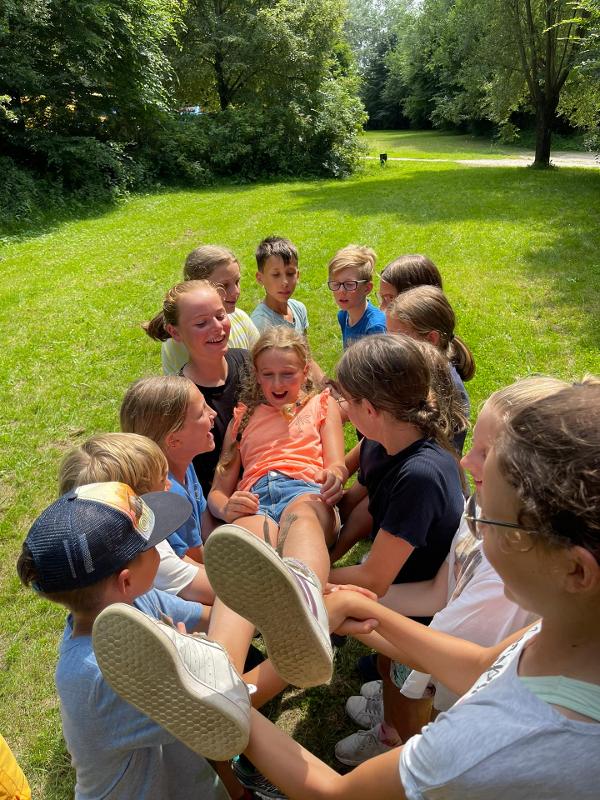 meisje wordt gedragen door andere kinderen op zomerkamp ronse