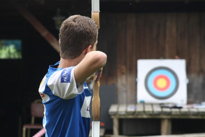jongen schiet pijl en boog op avonturen-gamekamp