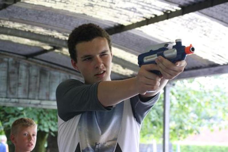jongen schiet met nerfgun op avonturen-gamekamp