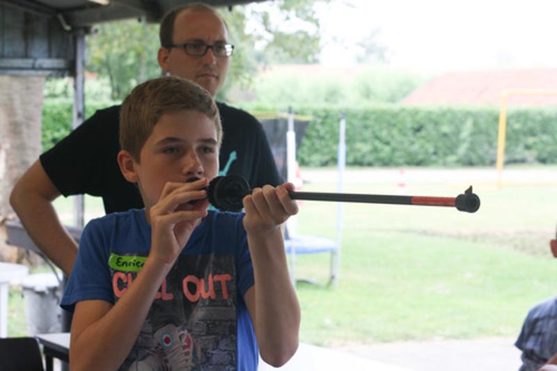 jongen richt met blaasgun op avonturen-gamekamp