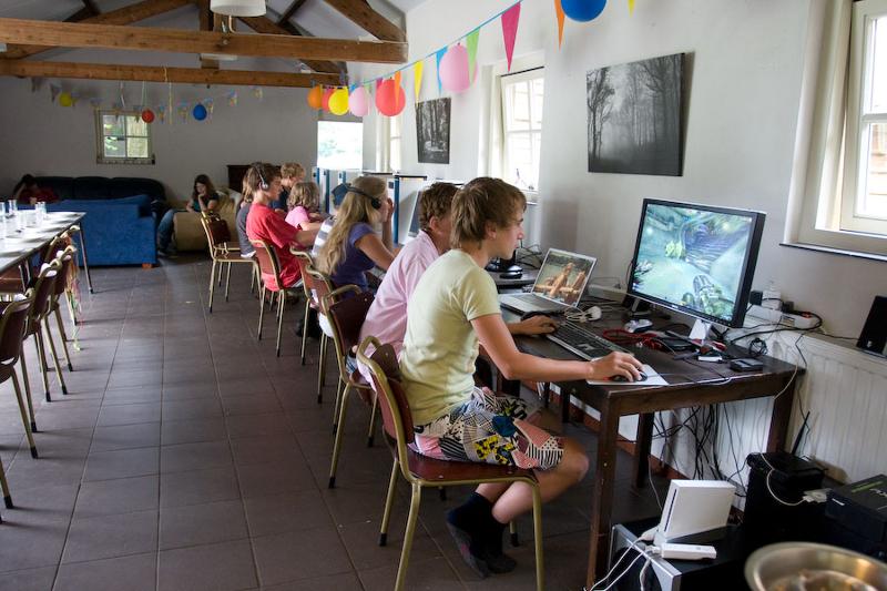 jongeren gamen in zaal met ballonnen op game en avonturenkamp