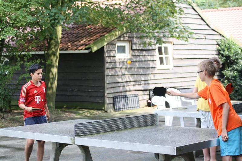 jongens spelen tafeltennis buiten op game en avonturenkamp