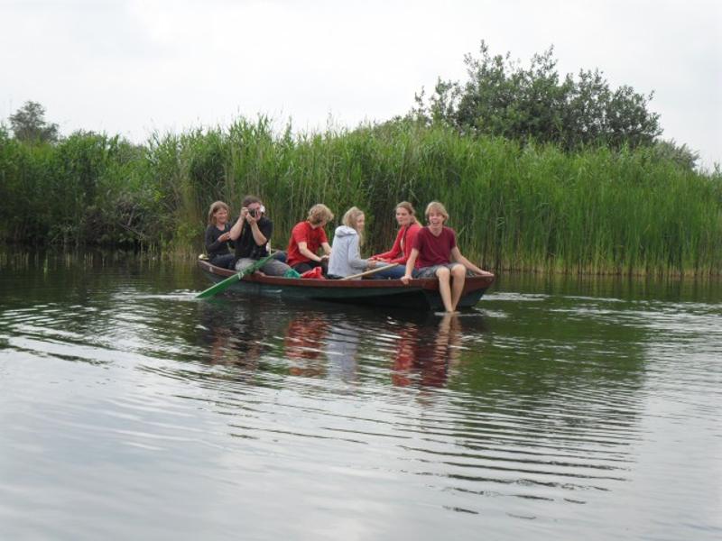 Kinderen varen in een bootje tijdens een natuurkamp