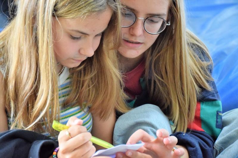 Twee dames kijken geconcentreerd naar een papiertje