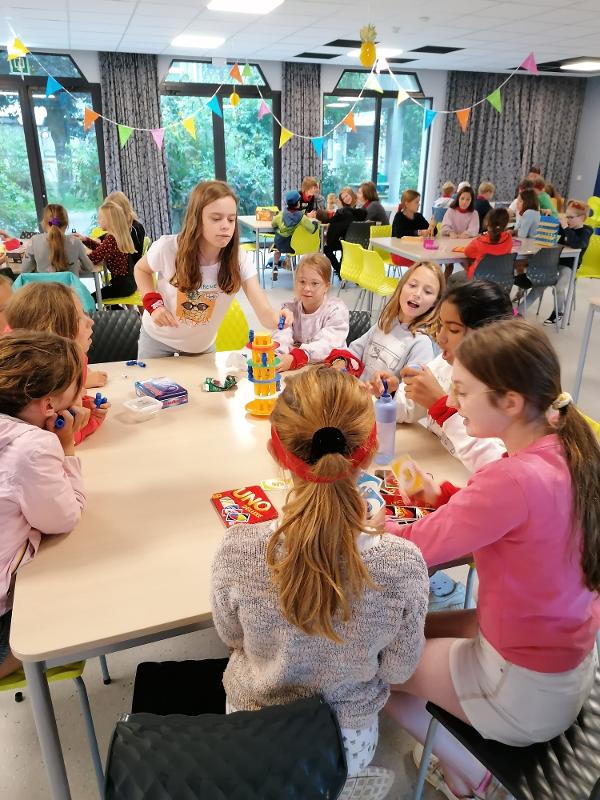 meisjes spelen binnen uno tijdens musical kamp
