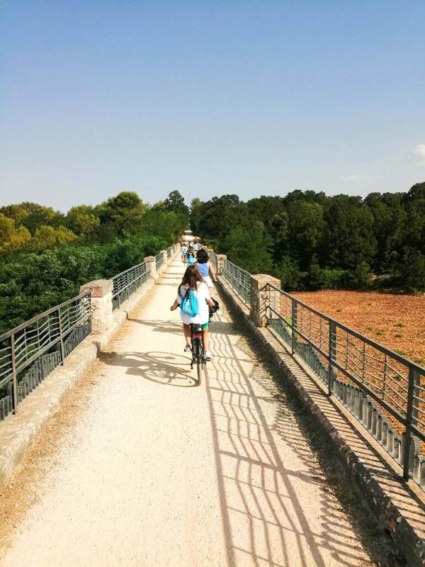 Deelnemers fietsen over een brug tijdens de taalreizen Italië