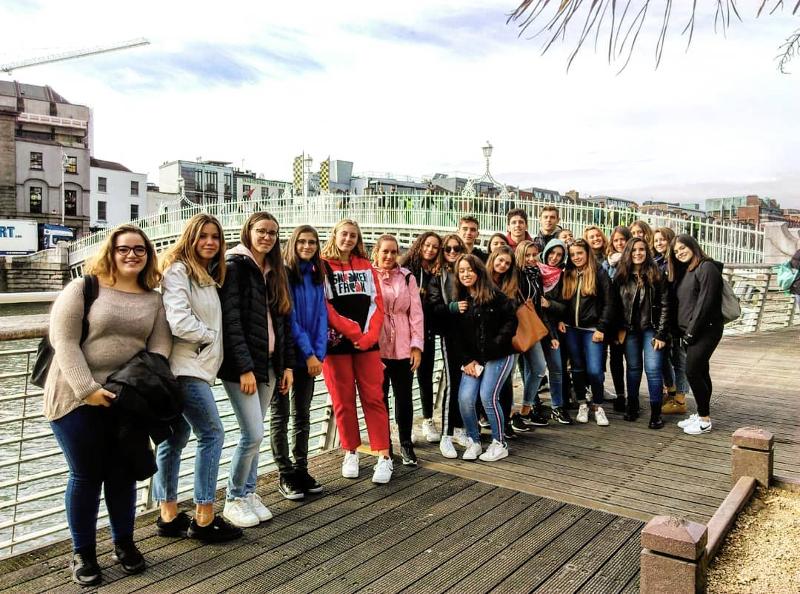 Groepsfoto van jongeren bij een rivier en brug tijdens een taalreis engels