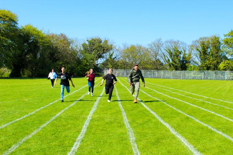 Jongeren rennen tijdens een race op een grasveld tijdens een taalreis engels