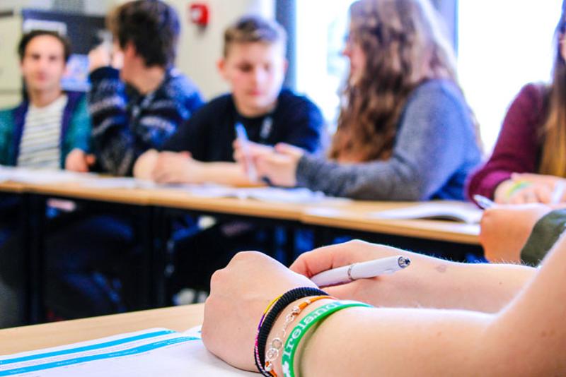 Jongeren praten met elkaar aan tafels tijdens een taalreis engels